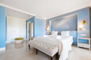 A bedroom with a bed, bedside tables, a bench, a wardrobe, and a mirror.