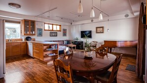 Una cocina amplia con armarios de madera, una mesa de comedor con sillas y un ventanal que proporciona luz natural.