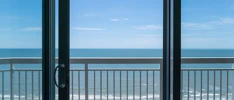 En balkon med udsigt til stranden og havet.