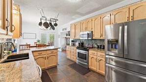 Eine moderne Küche mit Holzschränken, Edelstahlgeräten und einer Granit Arbeitsplatte.