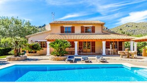 A two-story house with a swimming pool, outdoor seating, and a mountain backdrop. - REI PETIT.  Splendidly maintained garden for a perfect experience (Pollensa)