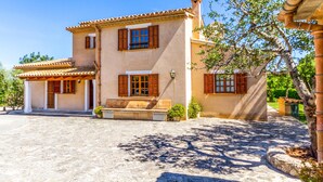 A two-story house with a tiled roof, wooden shutters, and a stone-paved courtyard. - REI PETIT.  Splendidly maintained garden for a perfect experience (Pollensa)