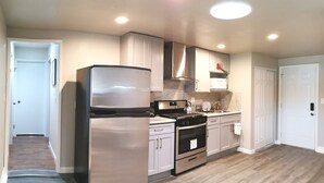 A modern kitchen with stainless steel appliances, white cabinetry, and a wooden floor. - Beautiful, Safe, Clean, Spacious 2 bd/1ba in N San Jose 951311 (San Jose)
