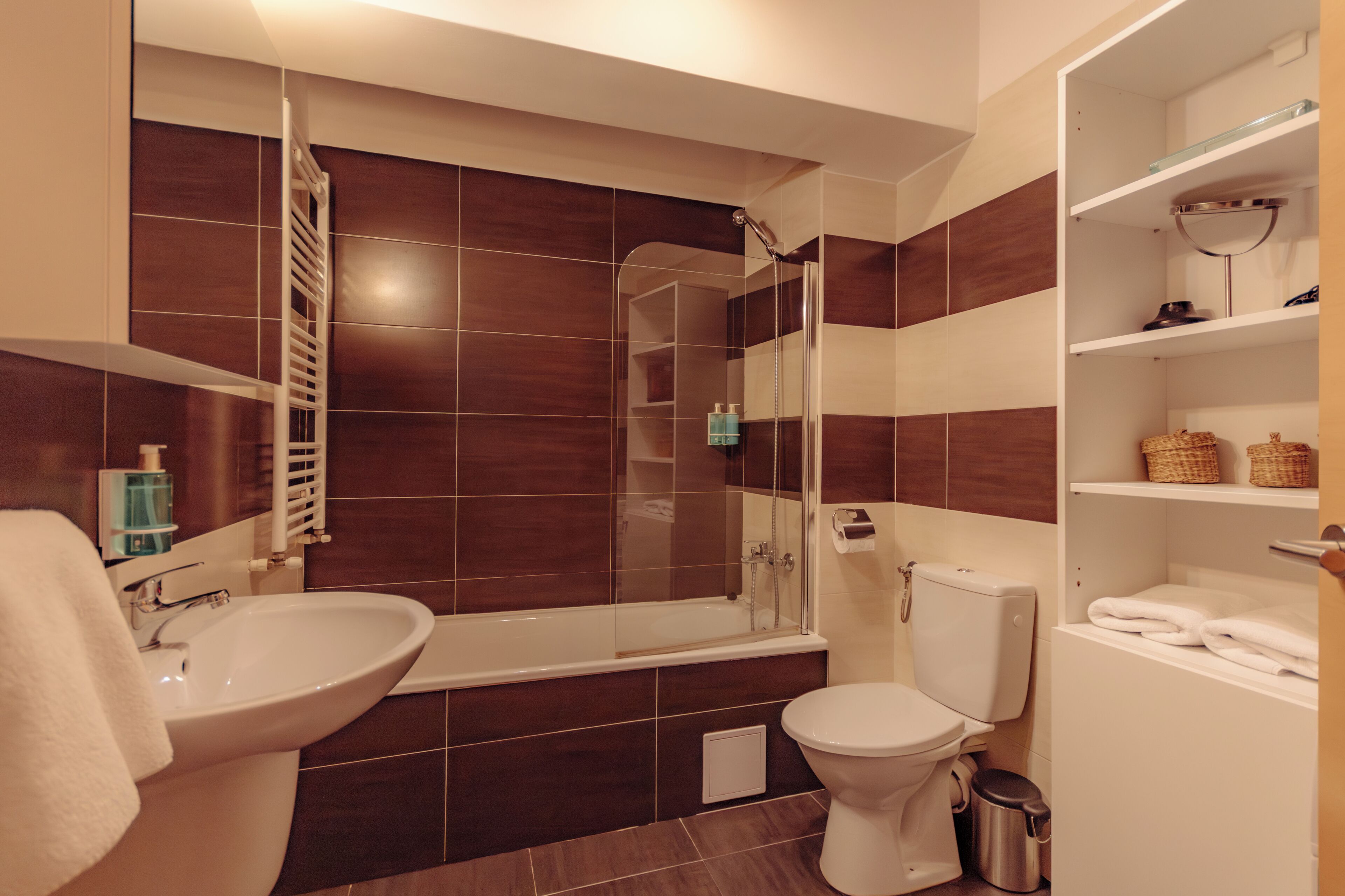 A modern bathroom with a bathtub, toilet, and sink.