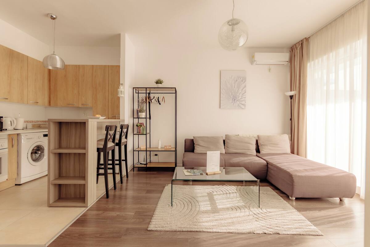 Uma sala de estar moderna com sofá, mesa de centro e área de jantar com cadeiras.