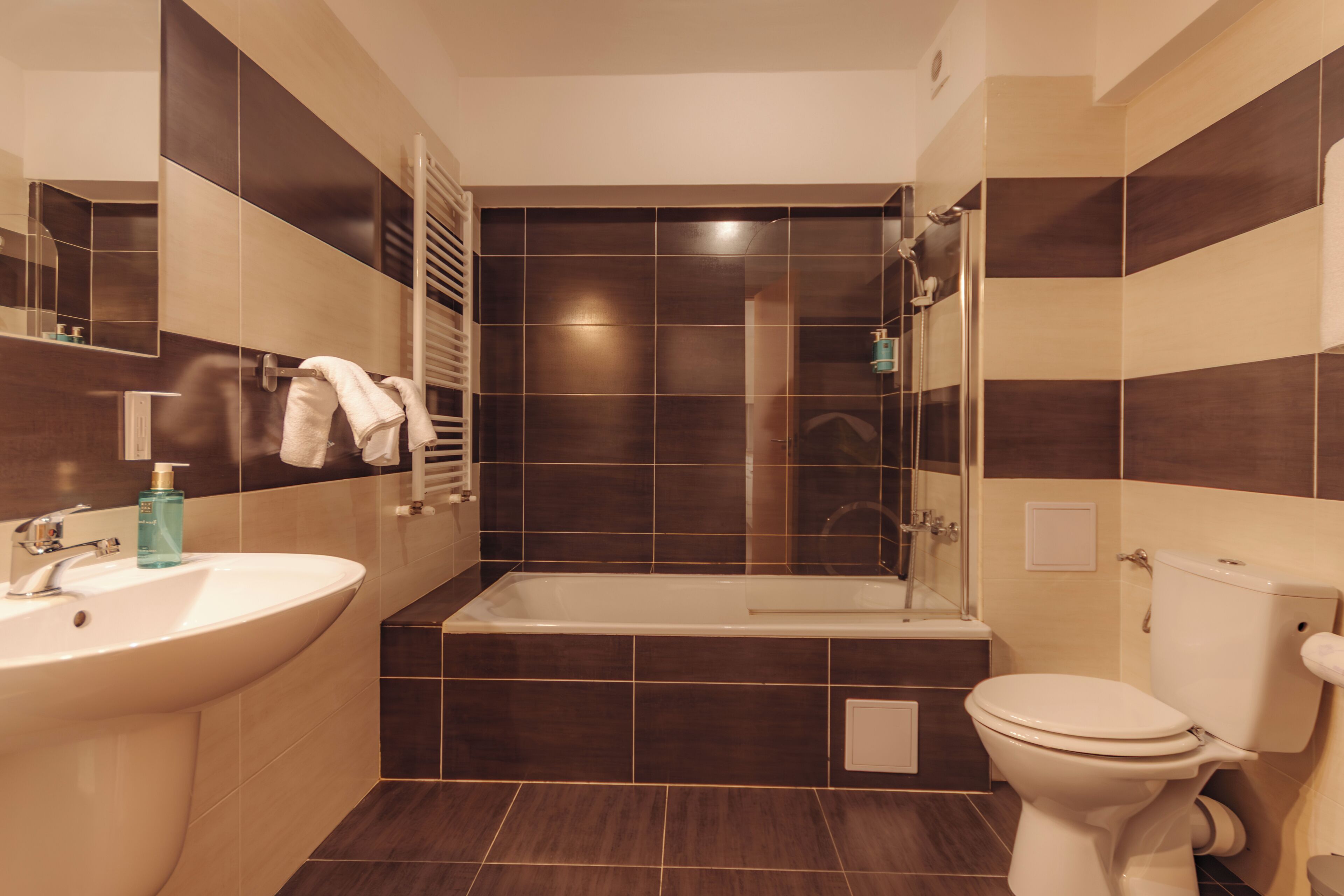 Un baño moderno con bañera, inodoro, lavamanos y cabina de ducha de vidrio.