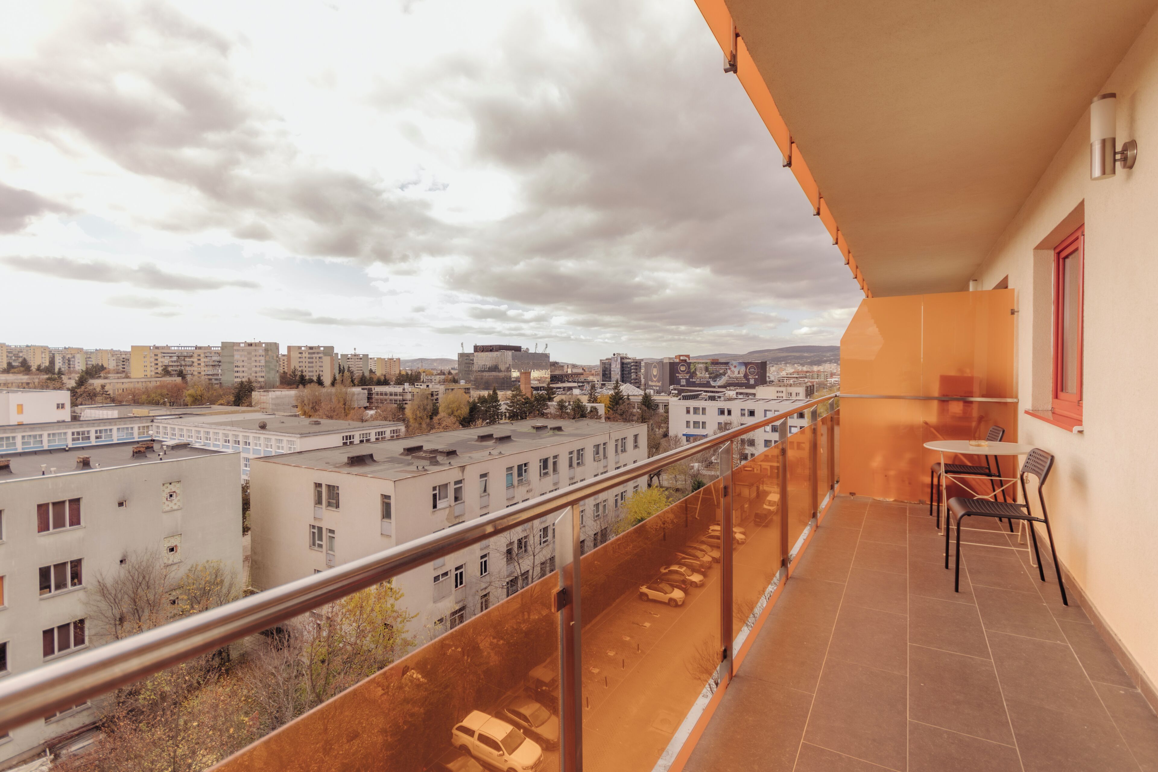 Un balcon donnant sur un paysage urbain, avec une table et des chaises.