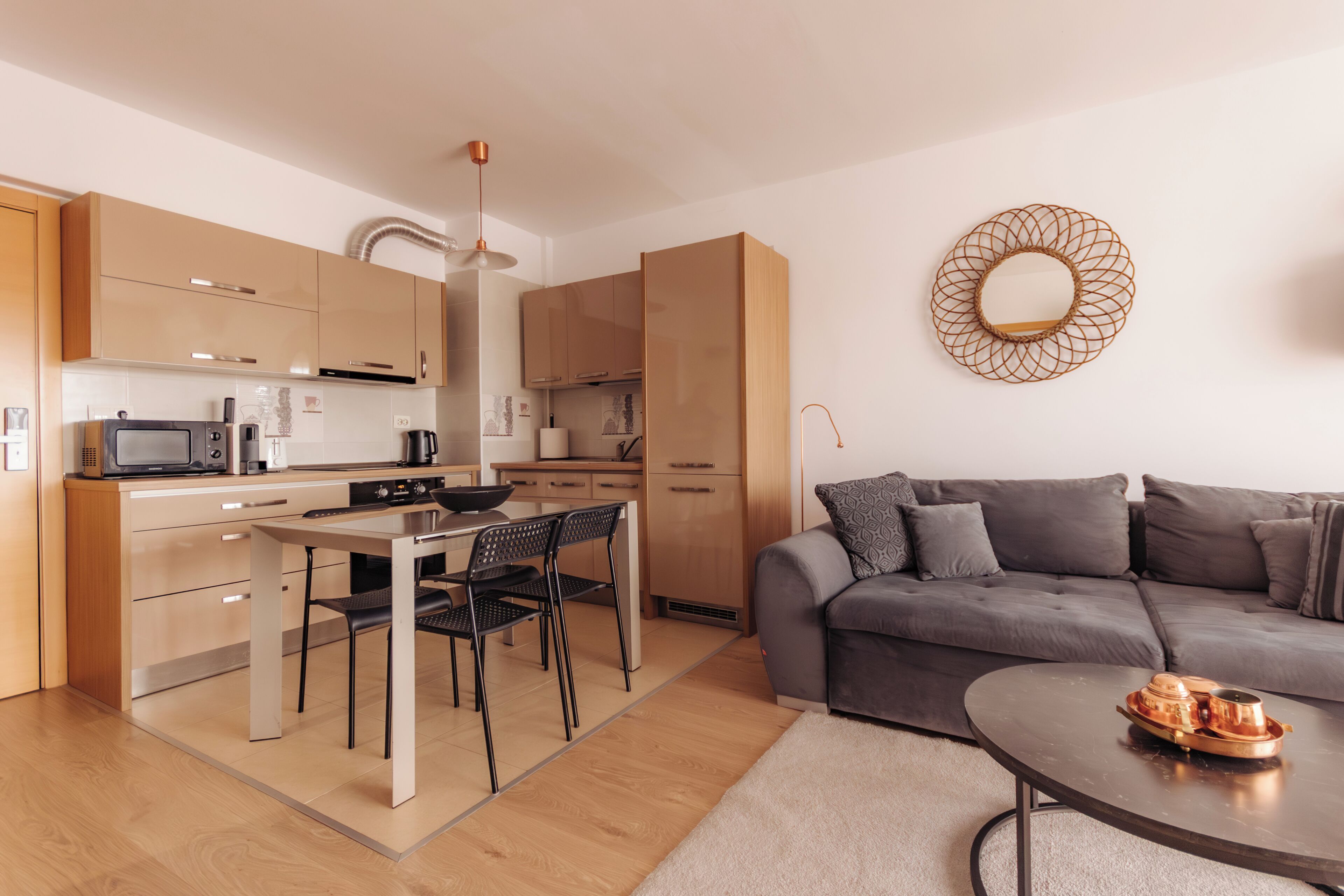 A modern kitchen with a dining area, a sofa, and a coffee table.
