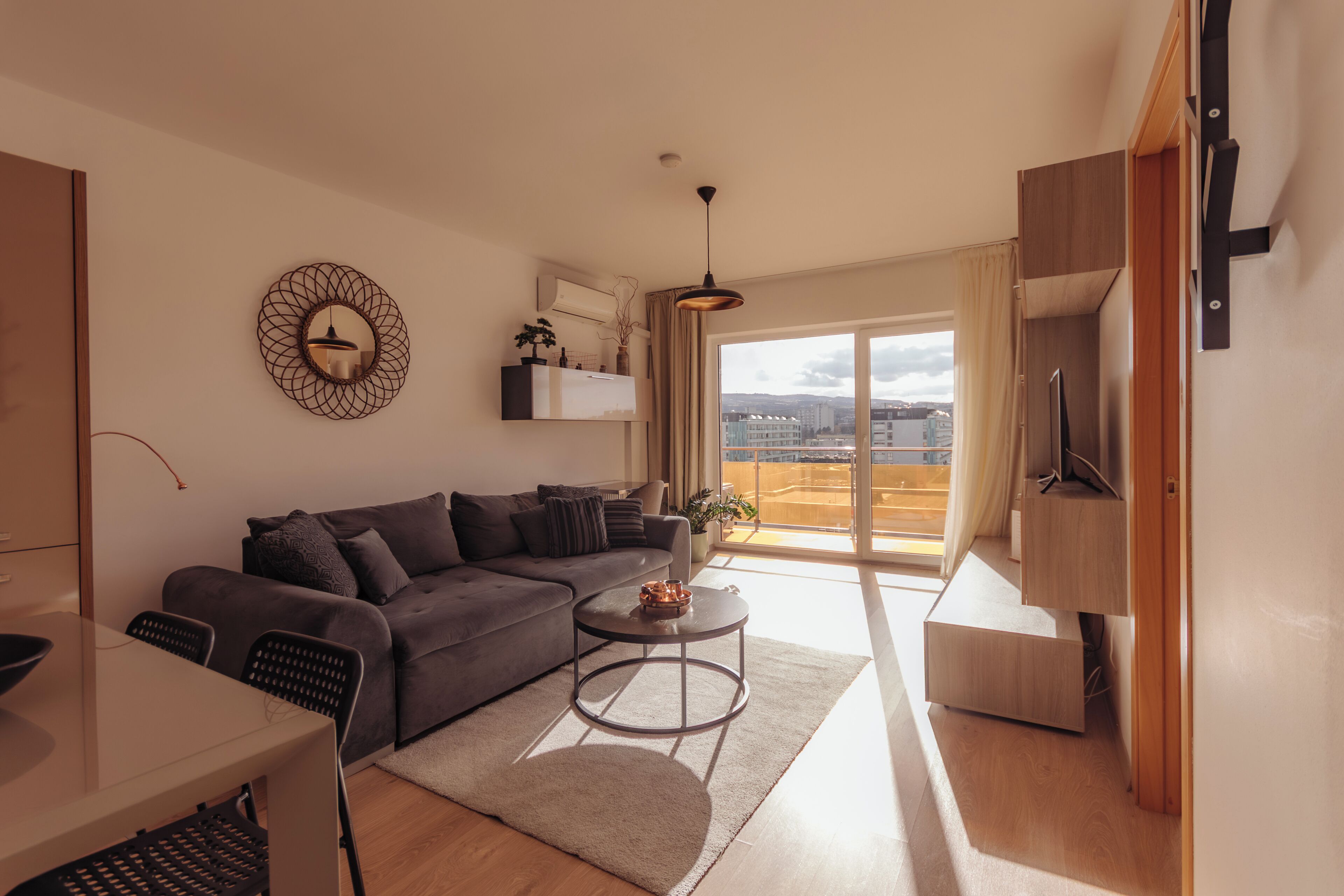 A modern living room with a sofa, coffee table, and a TV stand.
