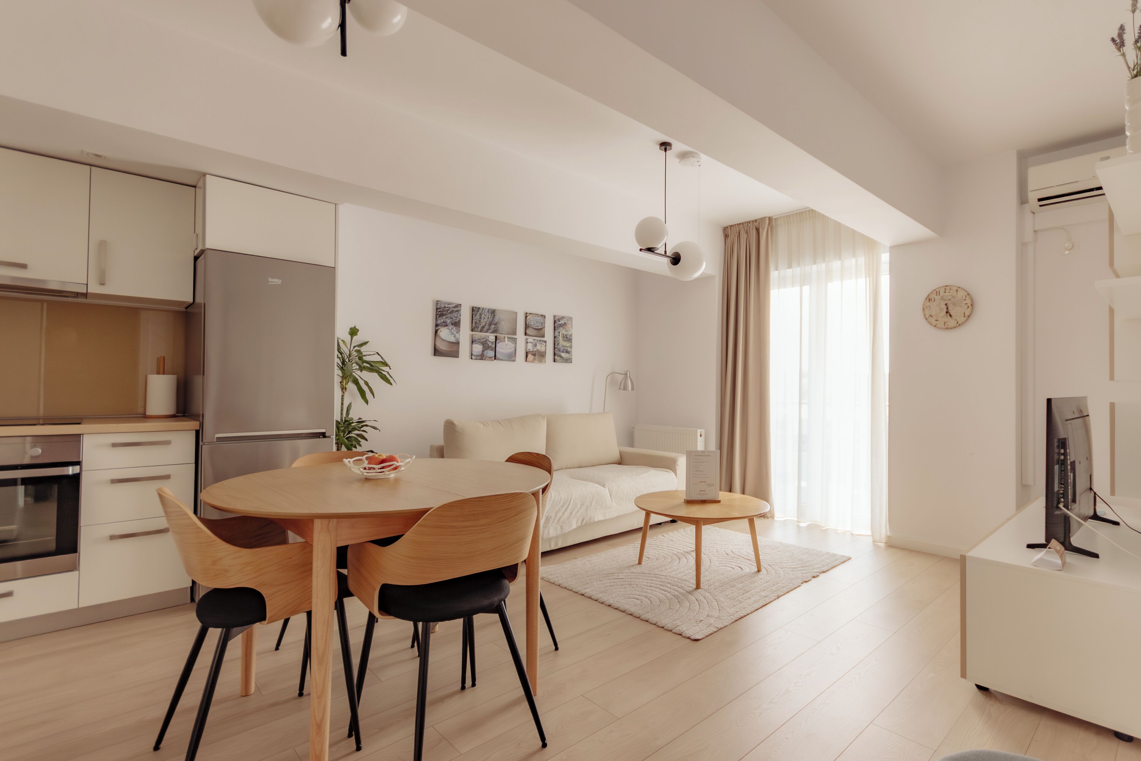 Una cucina moderna con tavolo da pranzo, sedie e frigorifero.