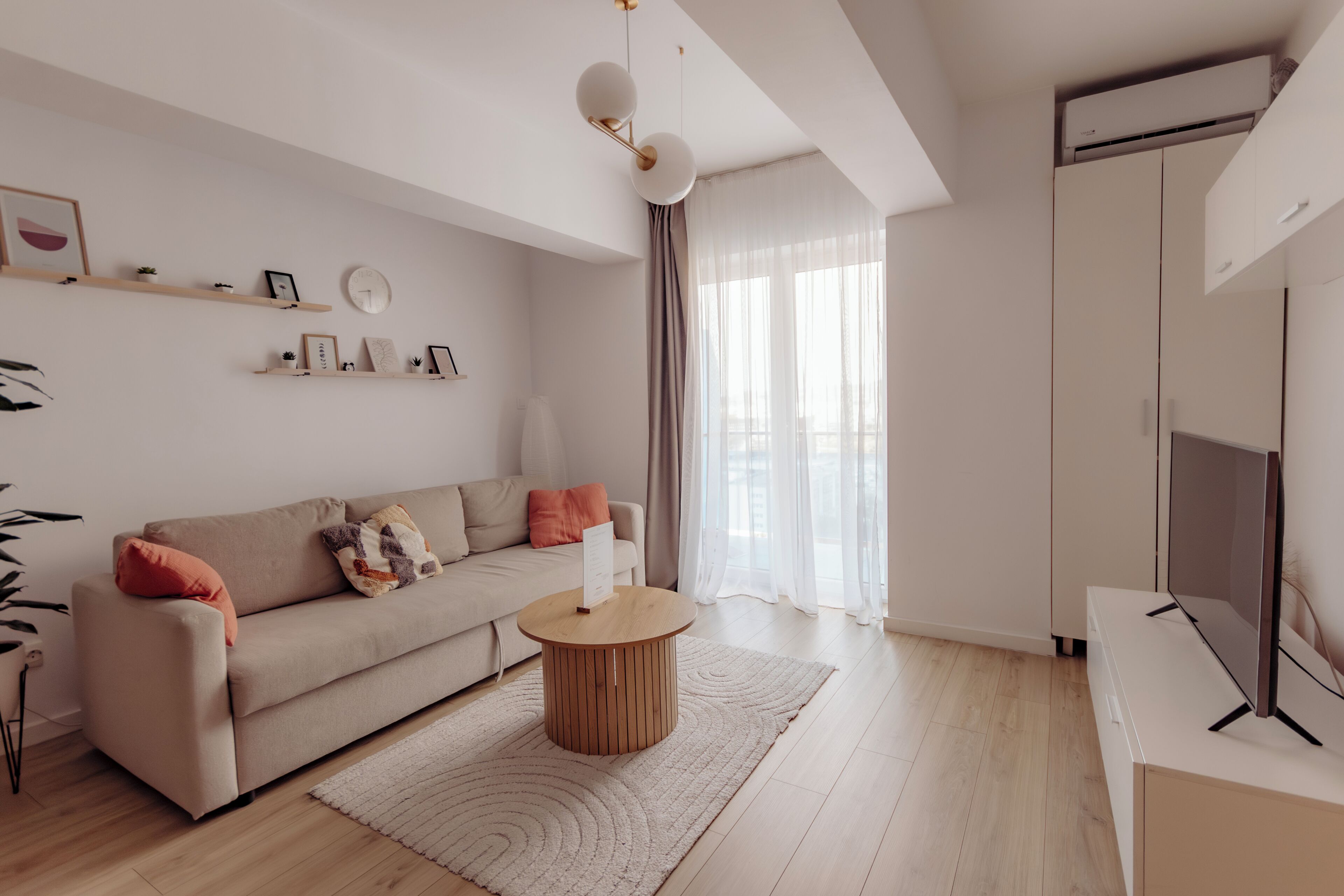 A modern living room with a sofa, coffee table, and TV stand.