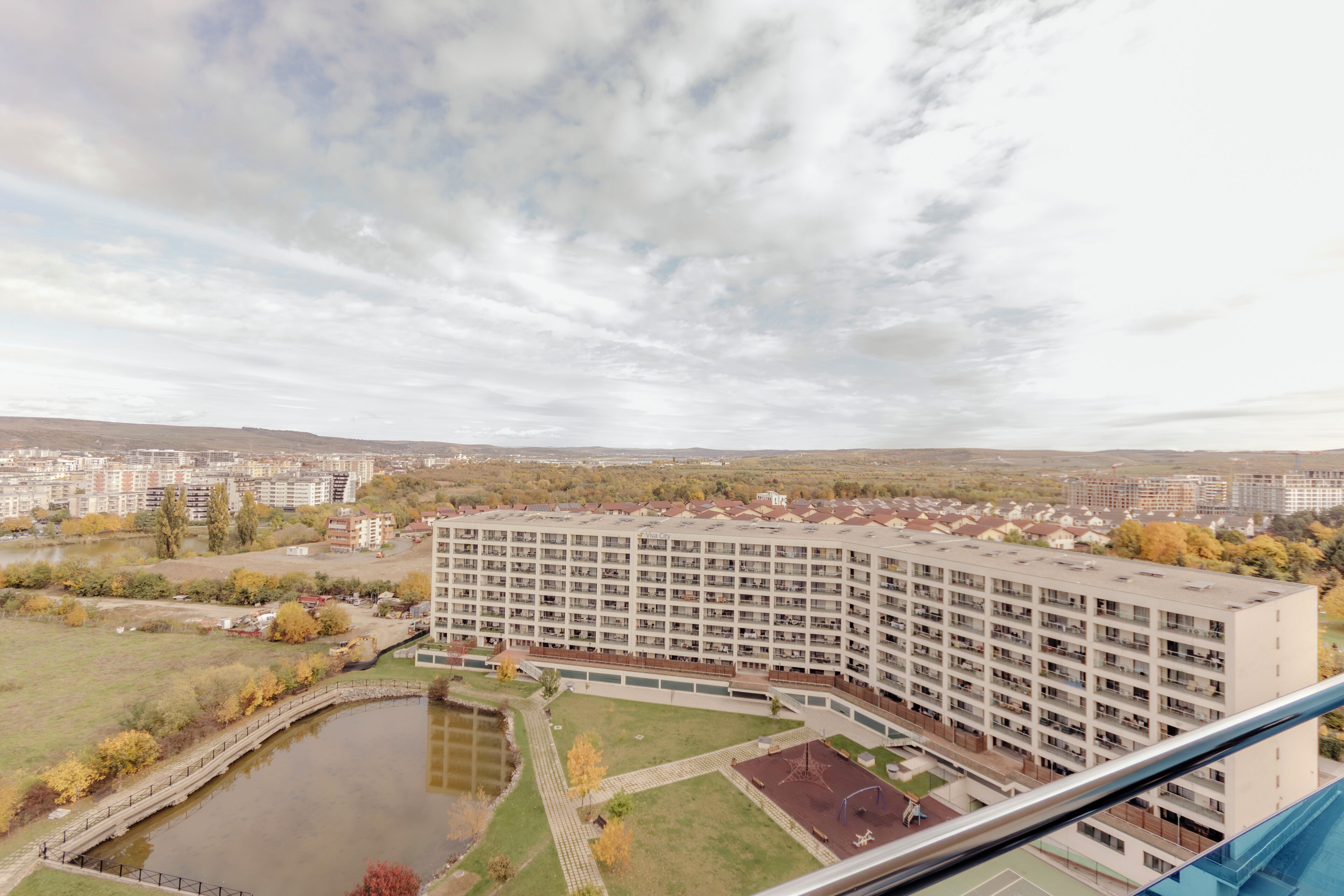 A high-rise building with multiple floors, a courtyard, and a body of water.