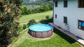 A house with a fenced swimming pool, surrounded by a well-maintained lawn and trees. - Ferienhaus mit Pool st Koloman (St. Koloman)