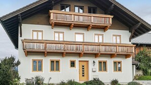 A two-story building with a wooden balcony on the upper floor and a door with a small window. - Ferienhaus mit Pool st Koloman (St. Koloman)