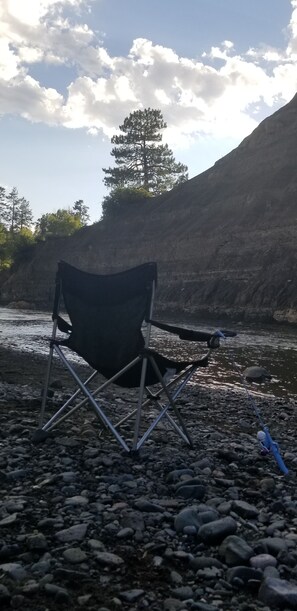 Relax by the river in a serene outdoor setting, perfect for fishing or unwinding.