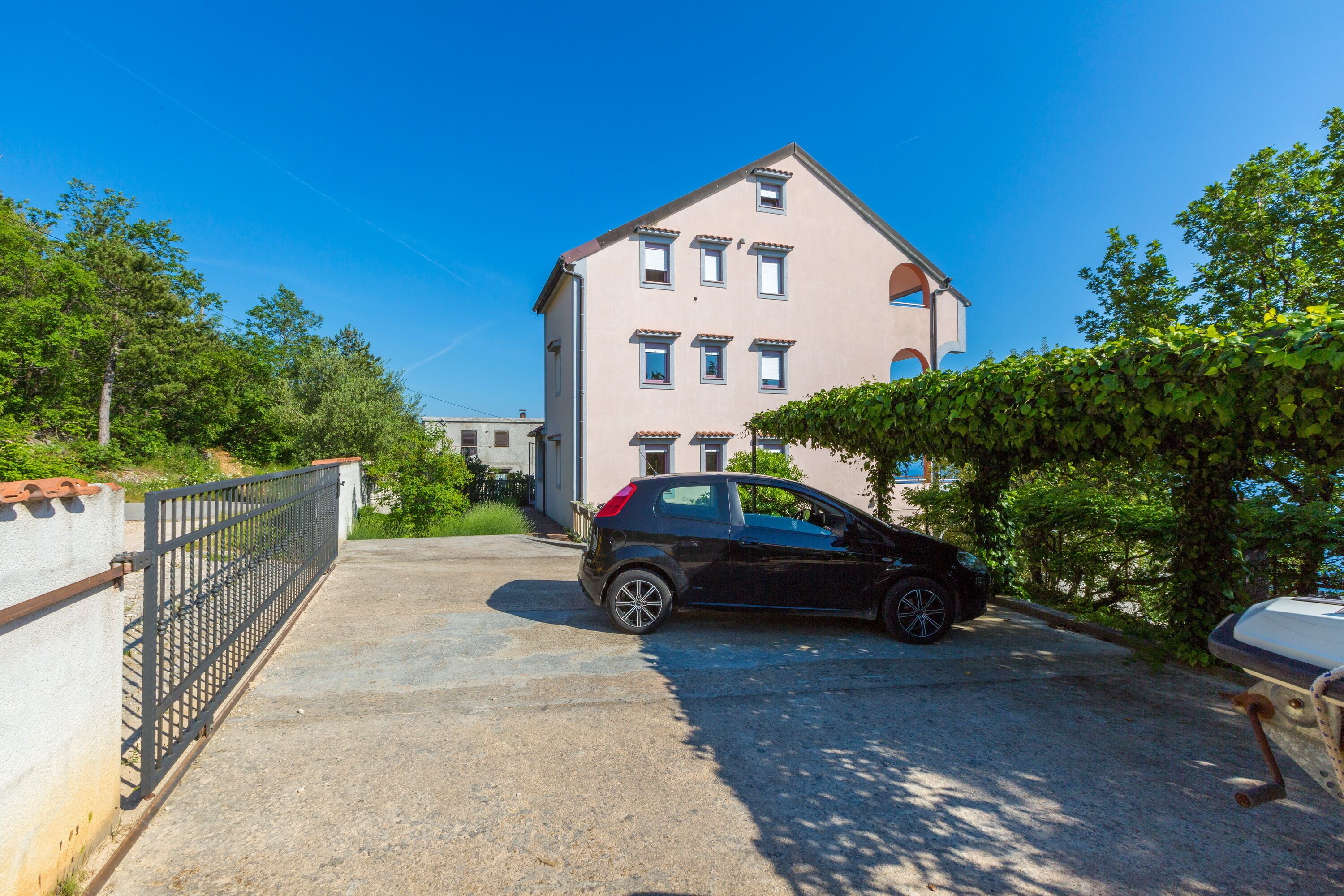 Un edificio di due piani con un'auto parcheggiata davanti.