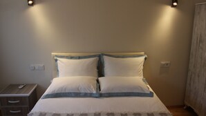 Camera da letto con un letto, comodini e luci a parete.