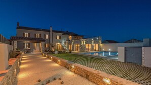 Una casa moderna con piscina, sendero de piedra y zona de estar al aire libre.
