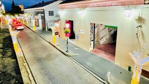 A street with buildings, a red car, and decorative lights. - Hotel Edelmira (Comitan de Dominguez)