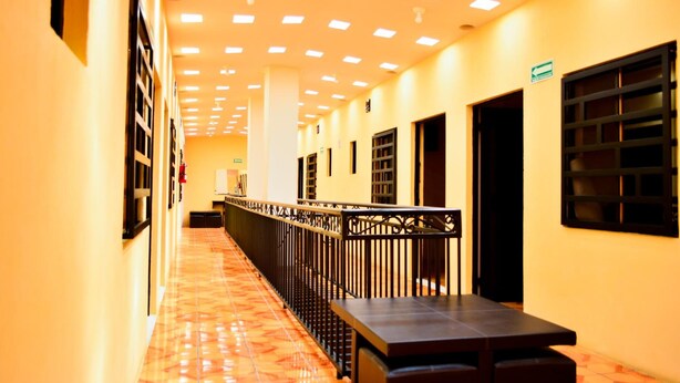 A corridor with tiled flooring, a metal railing, and doors leading to rooms. - Hotel Edelmira (Comitan de Dominguez)