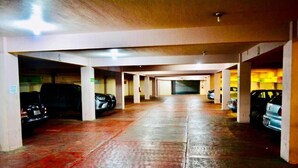 A multi-level parking garage with concrete pillars and a wet floor. - Hotel Edelmira (Comitan de Dominguez)