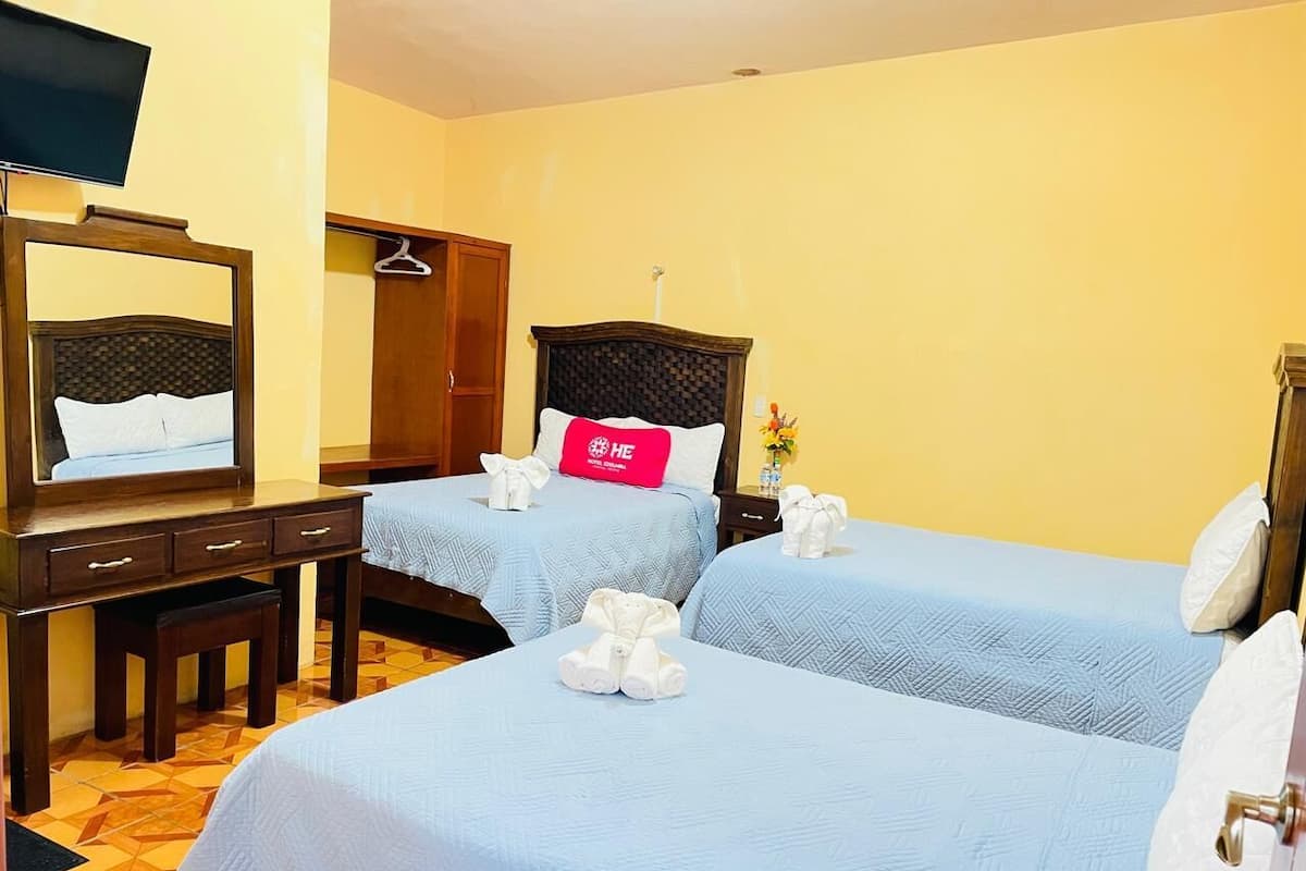 Une chambre d’hôtel avec deux lits, un bureau, une télévision et une armoire.