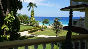 A view from a balcony overlooking a pool area with a clear view of the ocean. - Premium 3-BR Ocean view Condominium at Hispaniola Beach! (Sosúa)