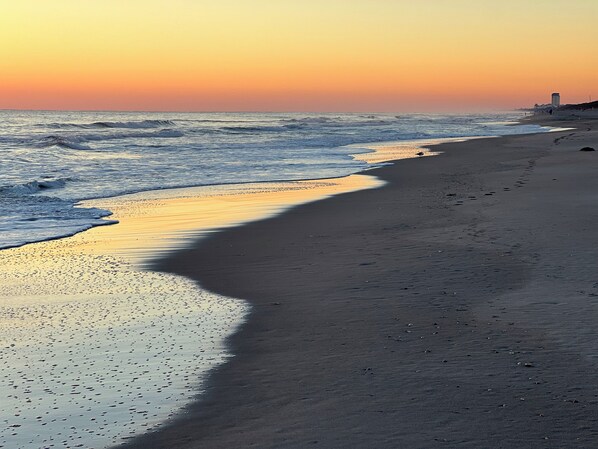 Ein Strand mit ruhiger See und Sonnenuntergang.