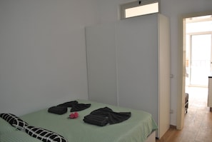 A bedroom with a bed, a wardrobe, and a small window. - Casa Tud Dret - luxurious apartments (Boa Vista)