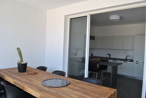 Uma cozinha moderna com armários brancos e bancada preta.