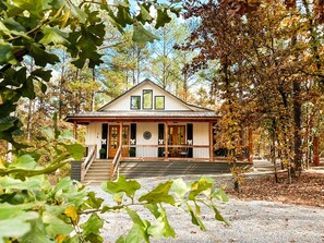 A two-story house with a porch, a front door, and a staircase leading to the entrance.