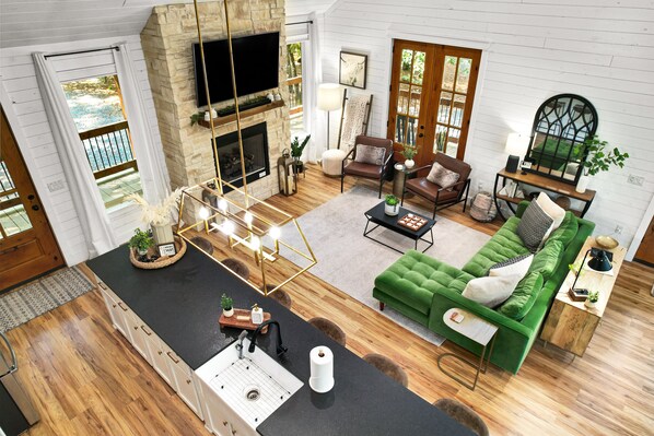 A spacious living area with a fireplace, green sofa, and a stone accent wall.