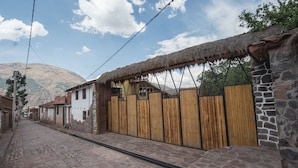 A cobblestone street lined with traditional buildings, some with thatched roofs and stone walls. - Eco Tampu - Andahuaylillas (Andahuaylillas)