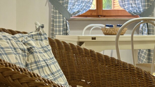 A wicker chair with a plaid cushion, a wicker basket, and a white chair with a blue cushion. - N040 - Numana, three-room apartment a stone's throw from the center (Numana)