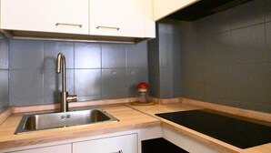 A kitchen with a stainless steel sink, wooden countertop, and white cabinets. - N040 - Numana, three-room apartment a stone's throw from the center (Numana)