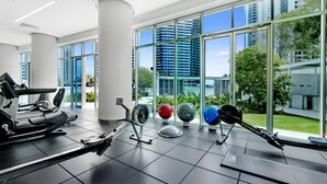 A modern gym with cardio equipment, weight machines, and exercise balls.