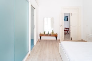 A bedroom with a bed, a desk with a mirror, and a chair. - Monteoliveto Modern Flat by Wonderful Italy (Napoli)