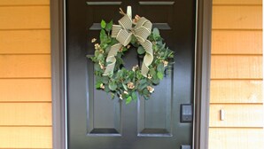 A dark brown front door with a wreath and a doormat that says "home". - Mountain Views & Solitude. This is Shadow Ridge. Hot Tub. (Fletcher)