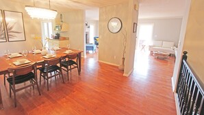 A dining area with a wooden table and chairs, a chandelier, and a clock on the wall. - Mountain Views & Solitude. This is Shadow Ridge. Hot Tub. (Fletcher)