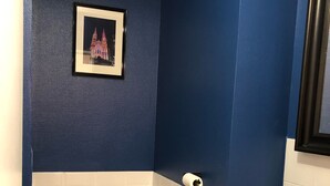 Een badkamer met toilet, wastafel en een ingelijst foto aan de muur.