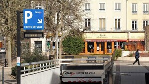 Een hotelingang met een bord voor Hotel de Ville en een parkeerbord.