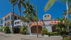 A hotel with a sign reading "La Pergola Restaurante" and a Walmart sign in the background. - Hotel Boutique La Pergola (Manzanillo)