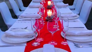 A long dining table set with white tablecloths, red runners, and candles. - Hotel Boutique La Pergola (Manzanillo)