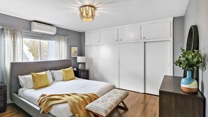 A modern bedroom with a large bed, bedside tables, a wardrobe, and a window with curtains. - Spacious Apt. Min to Downtown Culver City & Venice Beach (Culver City)