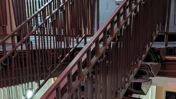 A staircase with a metal railing and patterned carpet.