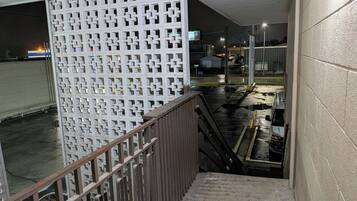 A stairway leading to a parking area with a white decorative fence on the left.