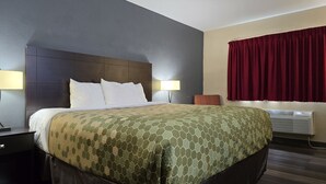 Une chambre d’hôtel avec un grand lit, deux lampes de chevet, un rideau rouge et un appareil de climatisation.