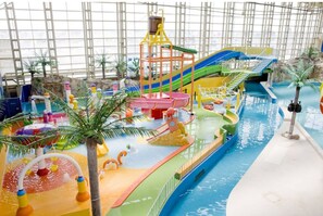 An indoor water park with slides, a wave pool, and various play structures.