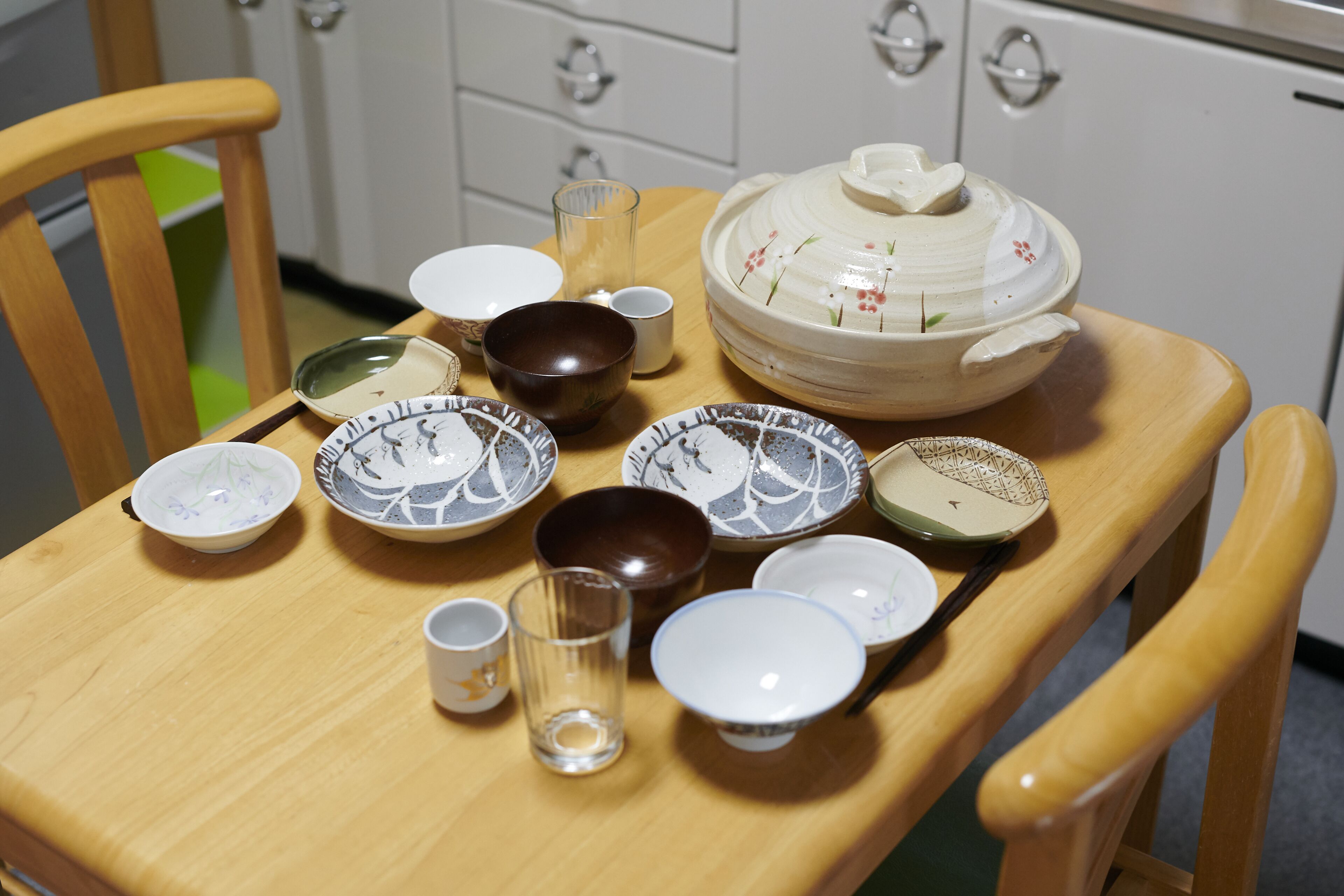 Une table à manger avec différents bols, tasses et un verre.