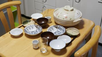 Une table à manger avec différents bols, tasses et un verre.